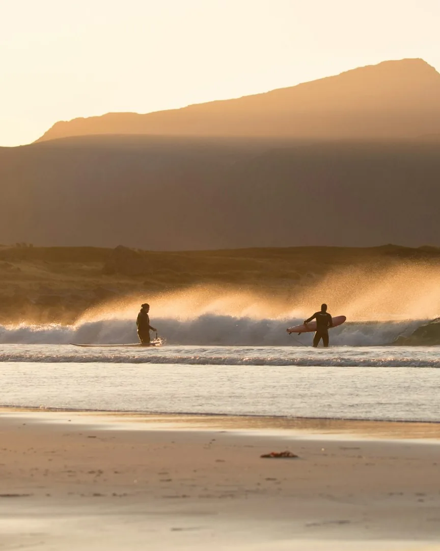 Surfers in low evening light