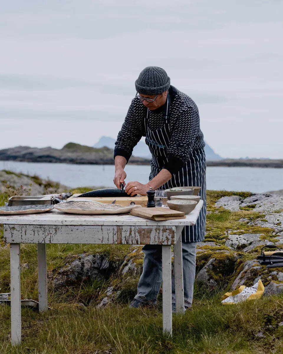 Chef preparing food on coastal rocks