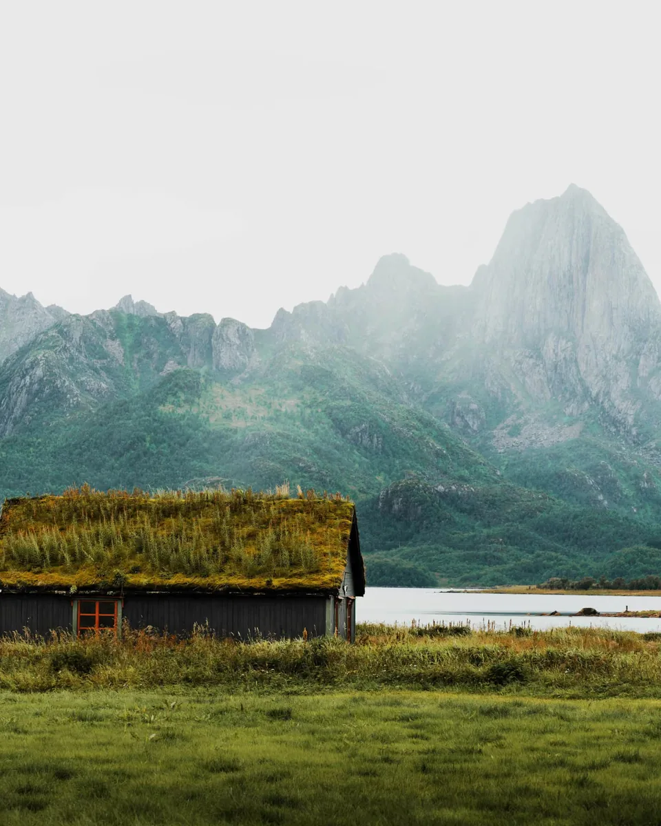 Turf-roofed house below steep peaks