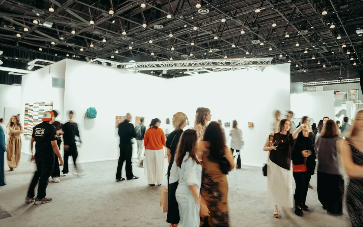 Guests moving through a bright gallery opening