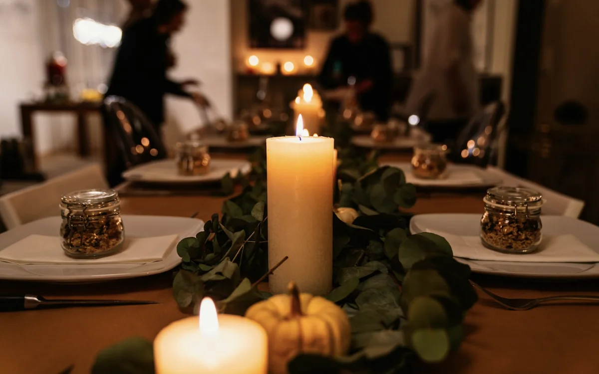 Candles and eucalyptus on a table laid for dinner