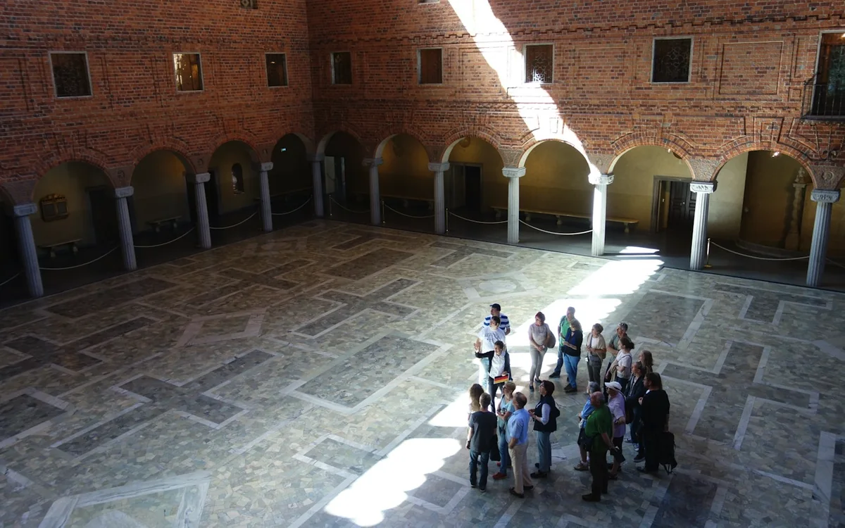 A visiting group being shown round a historic brick hall in Sweden
