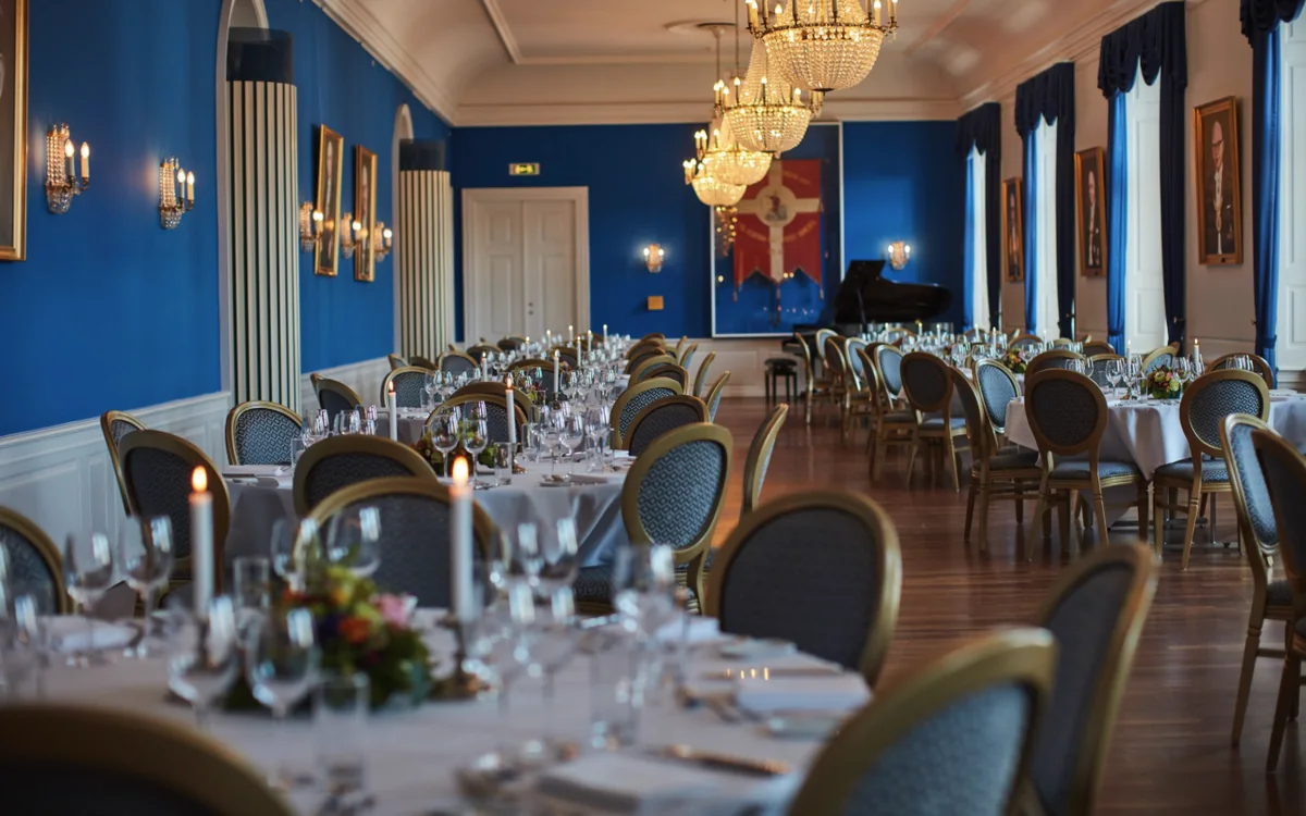 Odd Fellow Palæet: A blue hall with chandeliers, laid for dinner