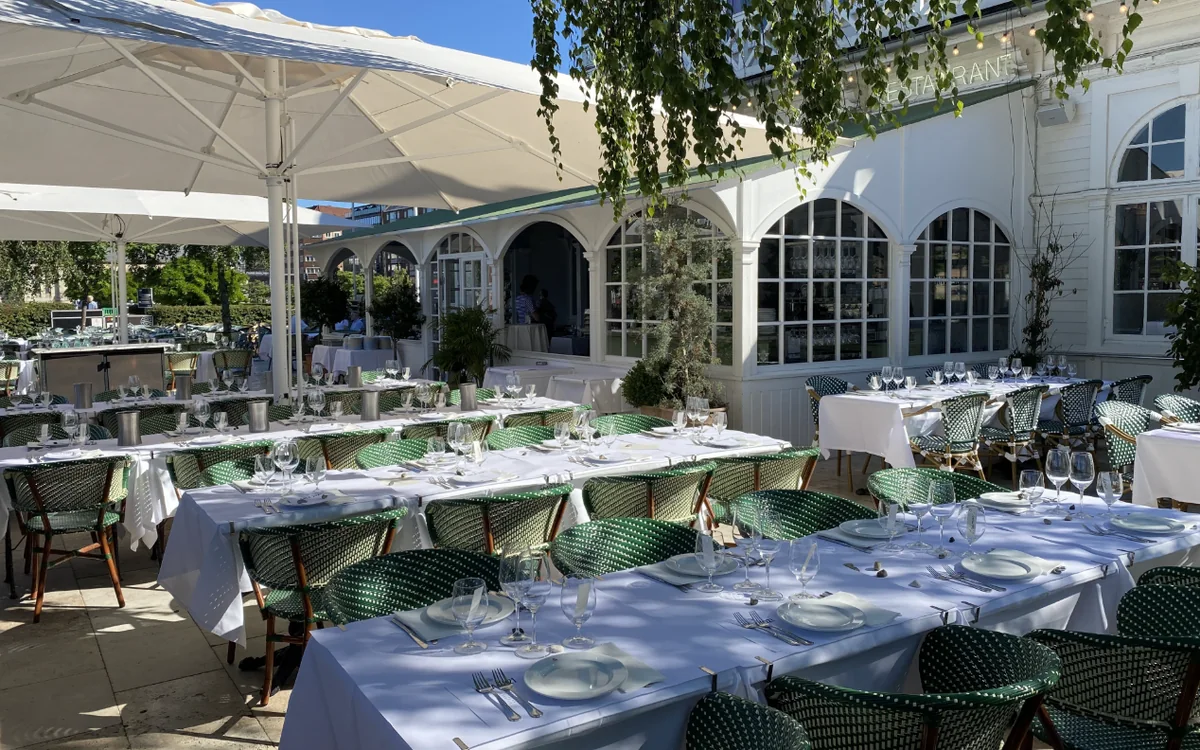 Søpavillonen: The terrace laid with long tables in front of the white pavilion
